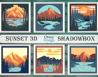 May include: A set of three shadow box art prints featuring sunset scenes with mountains, trees, and a lake. The prints are framed in white and have a 3D effect.