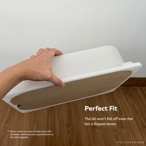 May include: White plastic storage bin with a wooden lid. The lid fits snugly and won't fall off even when the bin is flipped upside down. "Perfect Fit" is written in black text on the wooden lid.
