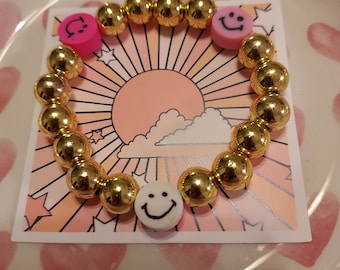 Golden bracelet with different shades of pink smiley faces made with love by thefiercefairy