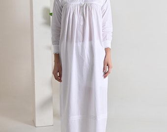 May include: A white cotton nightgown with long sleeves and a button-up front. The nightgown has a lace trim around the neckline and cuffs.