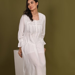 May include: A white cotton nightgown with a lace trim and button-up front. The nightgown has a relaxed fit and is knee-length.