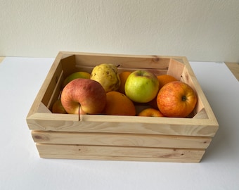May include: A wooden crate filled with fruit, including apples, oranges, and pears. The crate is made of natural wood and has a rustic look.