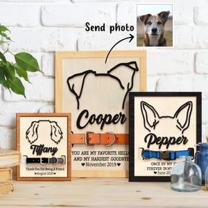May include: Three wooden signs with black dog silhouettes and collars. The signs have the names "Cooper", "Pepper", and "Tiffany" with personalized dates. The signs are on a wooden surface.