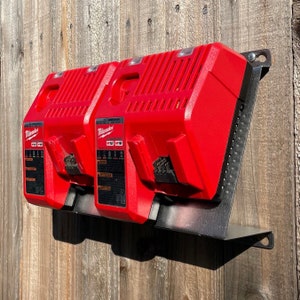 May include: A black metal wall mount with two red Milwaukee M18 18V lithium-ion battery chargers.