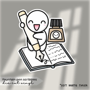 Könnte beinhalten: Ein gestanzter Vinyl-Aufkleber mit einer lächelnden Cartoonfigur, die einen Füllfederhalter über einem offenen Buch hält. Eine Tintenflasche befindet sich neben dem Buch. Der Aufkleber trägt den Text "fountain pen scribbles" und "die cut vinyl". Die Worte "soft matte finish" sind ebenfalls vorhanden.