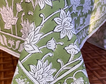 May include: Green tablecloth with a white floral pattern. The tablecloth has a border with a white floral design.