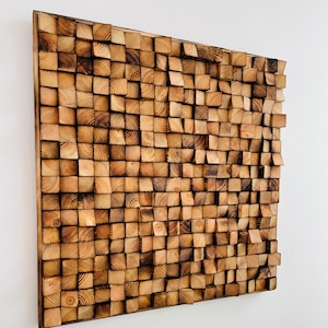 May include: A wall art piece made of wood blocks in various shades of brown. The blocks are arranged in a random pattern, creating a textured and visually interesting surface.