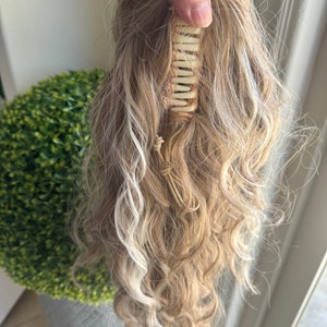 Tillstyle popielaty blond z podkreśloną falistą spinką w kucyk