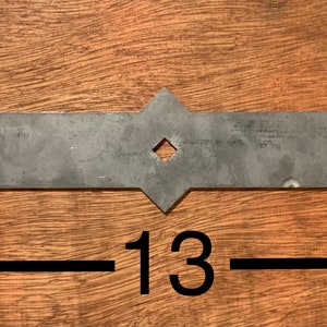 May include: A metal hinge with a decorative design. It measures 3-1/8 inches tall and 13 inches wide.