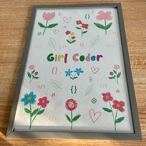 Può includere: Una stampa incorniciata con il testo "Girl Coder" in lettere colorate circondata da vari fiori disegnati a mano, cuori e simboli di codifica come parentesi graffe, parentesi angolari e le lettere "js" e "C++".