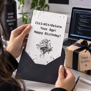 May include: A white rectangular birthday greeting card inside a black envelope. The card features black text that reads Ctrl+Alt+Delete Your Age! Happy Birthday! and a black and white sketch of computer keys labeled Ctrl, Alt, and Delete.