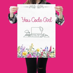 May include: A white poster with the text "You Code Girl" in pink lettering. The poster features a line drawing of a computer monitor, keyboard, and mouse. The bottom of the poster has a border of watercolour flowers.