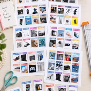 May include: A collection of educational flashcards featuring various technology and electronic device illustrations with labels. The set includes multiple sheets of printed cards, a stack of individual cards, scissors, and a notepad with the text Print Cut Learn Repeat.