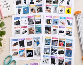 Op de afbeelding: Een verzameling educatieve flashcards met afbeeldingen van diverse technologie- en elektronische apparaten met labels. De set bevat meerdere vellen met gedrukte kaarten, een stapel losse kaarten, een schaar en een notitieblok met de tekst Print Cut Learn Repeat.