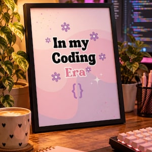 Op de afbeelding: Een ingelijste print met een lichtroze en paarse golvende achtergrond met de tekst In my Coding Era in een zwart-wit retro lettertype. Het ontwerp bevat paarse bloempictogrammen, kleine sprankelingen en een paar accolades aan de onderkant.