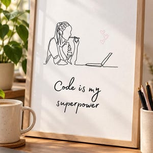 May include: A framed wall art print featuring a black line drawing of a person working at a laptop with three small pink hearts above it. The text below the illustration reads, Code is my superpower, written in a black cursive script font.
