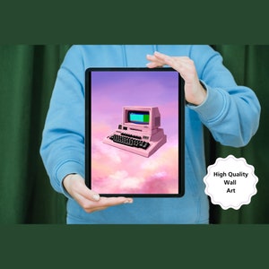 Può includere: Un'illustrazione digitale di un computer retrò rosa con uno schermo verde che galleggia su uno sfondo nuvoloso rosa e viola. L'immagine è incorniciata sullo schermo di un tablet tenuto dalle mani di una persona.