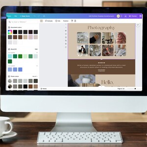 May include: A computer screen displaying a website design template with a brown background and the word "Photography" in a white font. The website design includes a grid of nine images, a text block, and a "Hello" greeting. The screen is surrounded by a white frame and is sitting on a wooden desk.