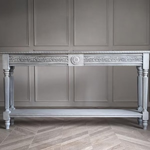 Consola Agiato con elegante diseño clásico, detalles tallados y estante. Un mueble atemporal para recibidor o salón.