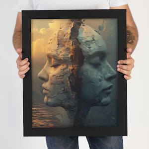 May include: A framed art print featuring a surreal image of two faces, one in shades of beige and the other in blue-gray, split down the middle. The artwork has a textured, stone-like appearance, set against a backdrop of a sunset and water.