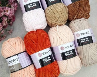 May include: Assortment of yarn balls in various colors, including pink, beige, brown, orange, and peach. Each ball has a label that reads "YarnArt Dolce".