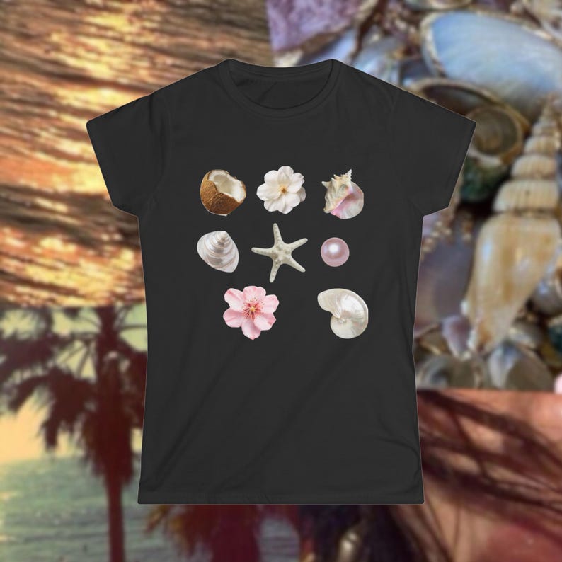 May include: Black t-shirt featuring a collection of seashell and floral illustrations. The design includes a coconut, white flowers, a pink pearl, a starfish, and various seashells. The shirt is a classic crew neck style.