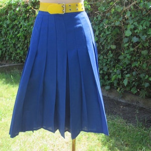 May include: A blue pleated skirt with a yellow belt. The skirt is knee-length and has a simple design.