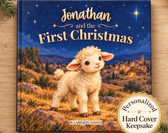 Puede incluir: Un libro de tapa dura titulado Jonathan and the First Christmas por Cameron Tanner. La portada muestra un cordero blanco en un campo de noche con un pueblo al fondo. Una pegatina dorada circular dice Personalized Hard Cover Keepsake.