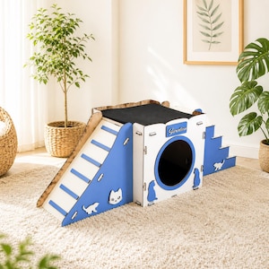 Puede incluir: Una casa para gatos de varios niveles con diseño azul y blanco. Cuenta con una rampa, escaleras y una entrada circular. La parte superior está cubierta de tela negra. Siluetas de gatos recortadas en los lados. La palabra "Garden" está escrita en el frente.