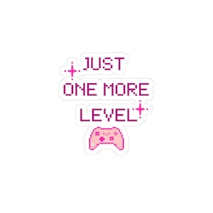 May include: A die-cut sticker featuring pixel art text that reads JUST ONE MORE LEVEL in a dark pink font. The design includes two small pink four-pointed star icons and a light pink pixelated video game controller at the bottom.