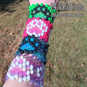 May include: A wide cuff bracelet made of multi-colored plastic pony beads arranged in a grid pattern. The bracelet features sections of neon green, black, pink, white, blue, and purple beads. Text reads 24 Variations DM for custom colors.