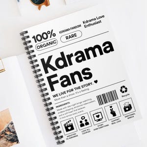 Può includere: Un quaderno a spirale bianco con le parole "Kdrama Fans" in grandi lettere nere. Il quaderno include testo come "We live for the story" e "Addicted to Kdramas". La copertina presenta anche le parole "100% Organic" e "Rare".