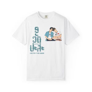 Peut inclure: T-shirt blanc avec un motif de deux personnes enlacées et du texte turquoise. Le texte indique "9 30 motelclub 2 years" et "LOVE ME IF YOU SWEAR". Le motif comprend un cœur.