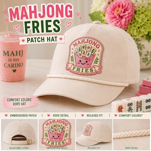 May include: A cream-coloured baseball cap featuring a decorative embroidered patch of a pink container filled with mahjong tiles and the text MAHJONG FRIES. The hat includes a white rope detail across the brim and an adjustable strap at the back.