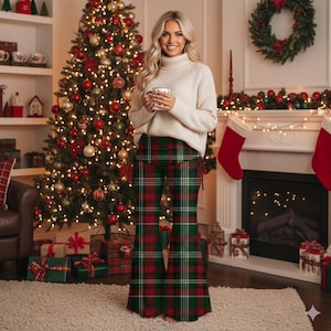 May include: A woman wearing a cream-colored turtleneck sweater and flared plaid pants in red, green, and white. The pants have a high waist and a wide leg. The background includes a decorated Christmas tree and a fireplace.