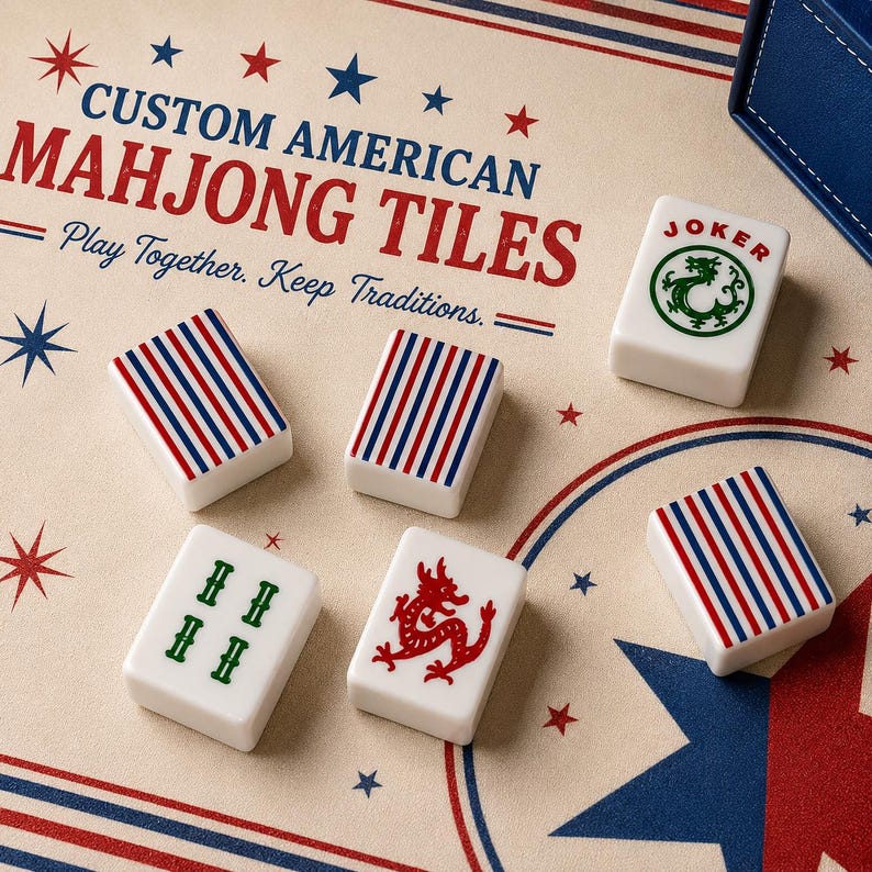 May include: White rectangular Mahjong tiles with red and blue vertical stripes, a green dragon Joker tile, a green character tile, and a red dragon tile. The tiles rest on a beige surface printed with the text CUSTOM AMERICAN MAHJONG TILES.