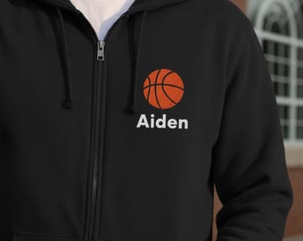 May include: Black zip-up hoodie featuring a basketball graphic and the name "Aiden" in white. The basketball is orange with black lines. The hoodie has a drawstring hood and a full-length zipper.