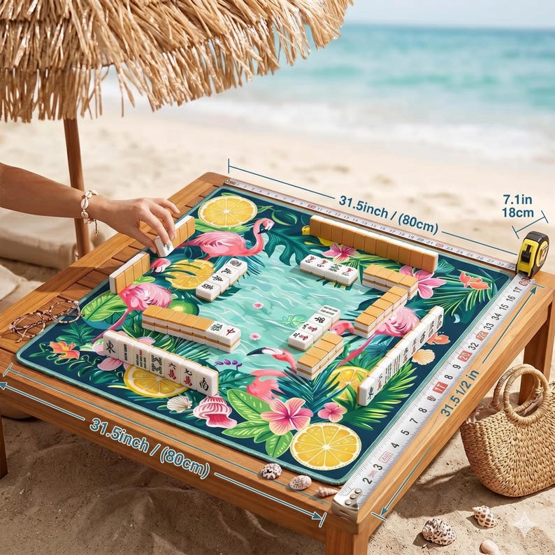 May include: A wooden Mahjong table with a tropical design, featuring pink flamingos, lemons, and lush greenery. The table measures 31.5 inches (80cm) square and 7.1 inches (18cm) high. Mahjong tiles are arranged on the playing surface, ready for a game.