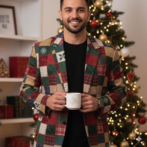 May include: A patchwork blazer in red, green, and gold, featuring snowflake and plaid patterns. The blazer is worn over a black shirt. A white mug with a snowflake design is held in front of a Christmas tree.