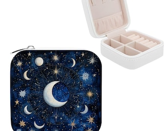 May include: A white, square jewelry box with an open lid, revealing compartments for storage. Beside it, a square, zippered pouch with a celestial design featuring moons, stars, and a dark blue background.