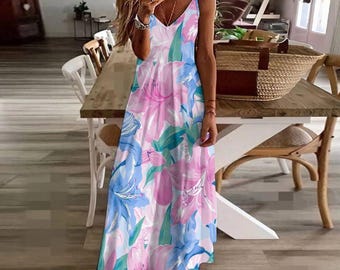 May include: A white maxi dress with a pink and blue floral print. The dress has a V-neckline and spaghetti straps.