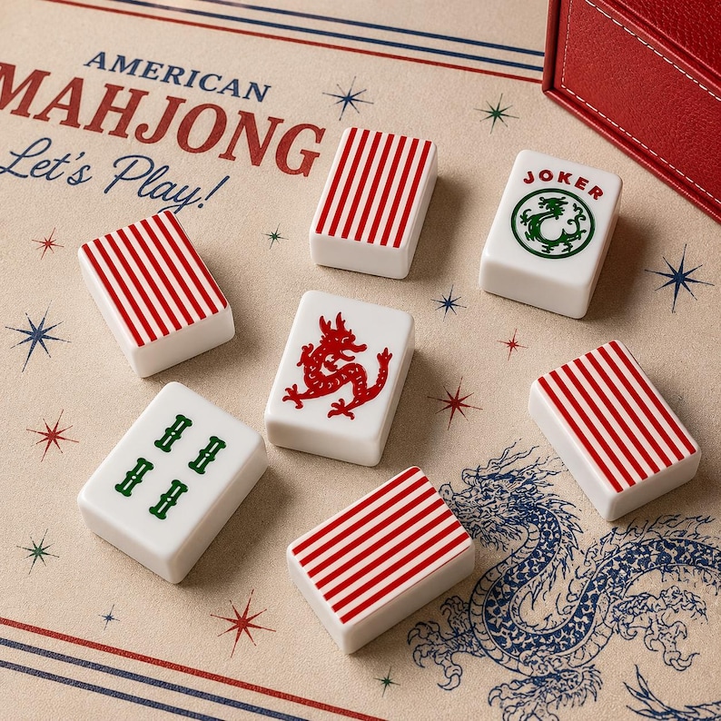 May include: A set of white Mahjong tiles featuring red striped patterns, a red dragon, a green dragon, and a Joker tile with a green dragon graphic. The tiles are arranged on a beige surface printed with the text American Mahjong Let's Play.