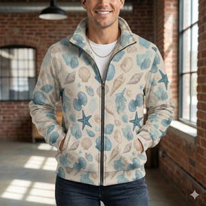May include: A beige zip-up jacket featuring a pattern of blue seashells and starfish. The jacket has a high collar, a black zipper, and two front pockets. The overall design has a coastal theme.