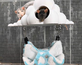 May include: A white cloud-shaped pet house with two openings, suspended above a blue and white patterned hammock. Two small rats are visible, one inside the cloud and one on top. The cage has a wire frame.