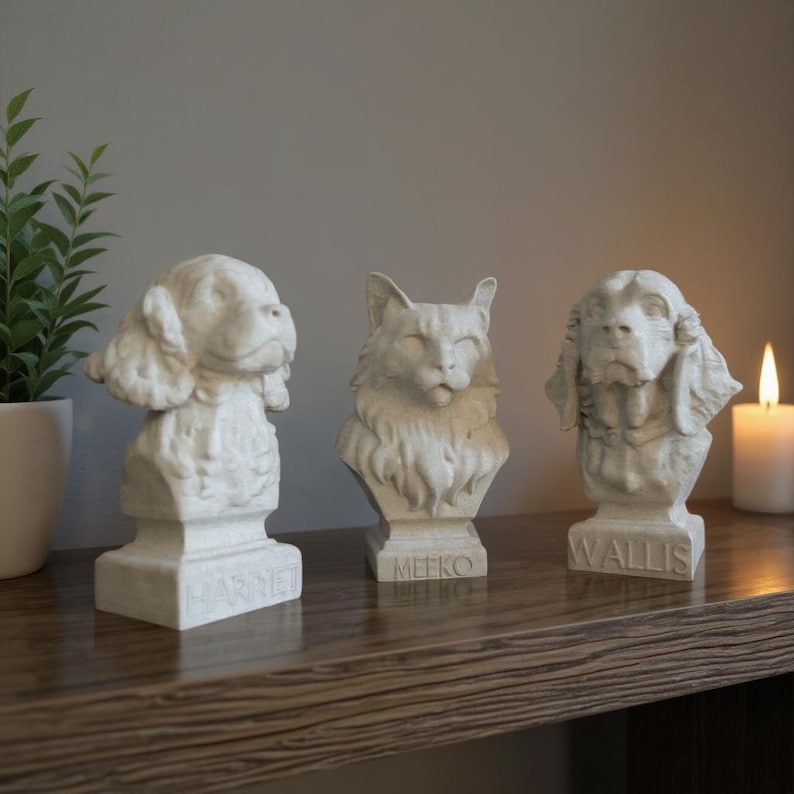 Three personalised pet bust keepsakes displayed on a wooden shelf beside candles