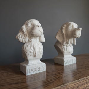 Side view of personalised dog and cat bust keepsakes on a wooden surface