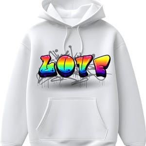 Pode incluir: Moletom branco com capuz e bolso frontal. A palavra "LOVE" está escrita em letras de estilo grafite, com um gradiente de arco-íris e contornos pretos. Salpicos e gotas de tinta cinza estão atrás da palavra.