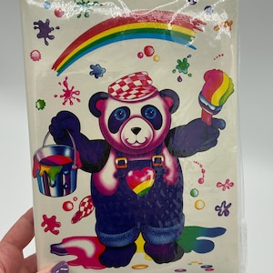 May include: A notebook featuring a cartoon panda wearing overalls and a checkered hat, holding a paintbrush and a paint bucket. The panda is surrounded by colourful paint splatters and a rainbow.