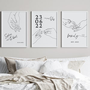 May include: Three black and white line art prints with hand drawings. The first print shows two hands holding each other with the text "Sophia and Robert 10.03.2010." The second print shows two hands holding each other with the text "23 06 22 and Yes." The third print shows two hands holding each other with the text "family EST. 2023."