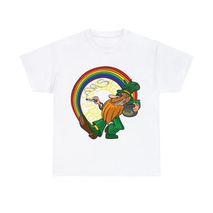May include: White t-shirt featuring a cartoon leprechaun with a red beard, green outfit, and sunglasses, holding a pot of gold. A rainbow arches behind the leprechaun, with the words "Pot O' Gold" in a yellow font.